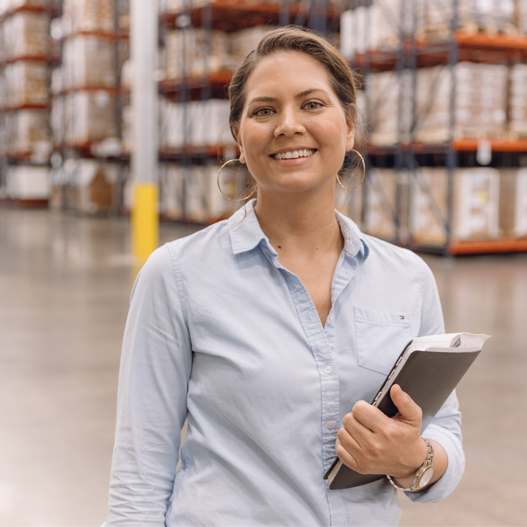 Smiling and Confident Female Team Member inside LSL Warehouse Handling Inventory