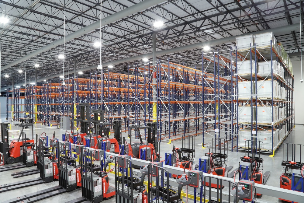 Top View of LSL Warehouse with Forklifts, Rows of Empty Racks, and Boxes of Stored Items