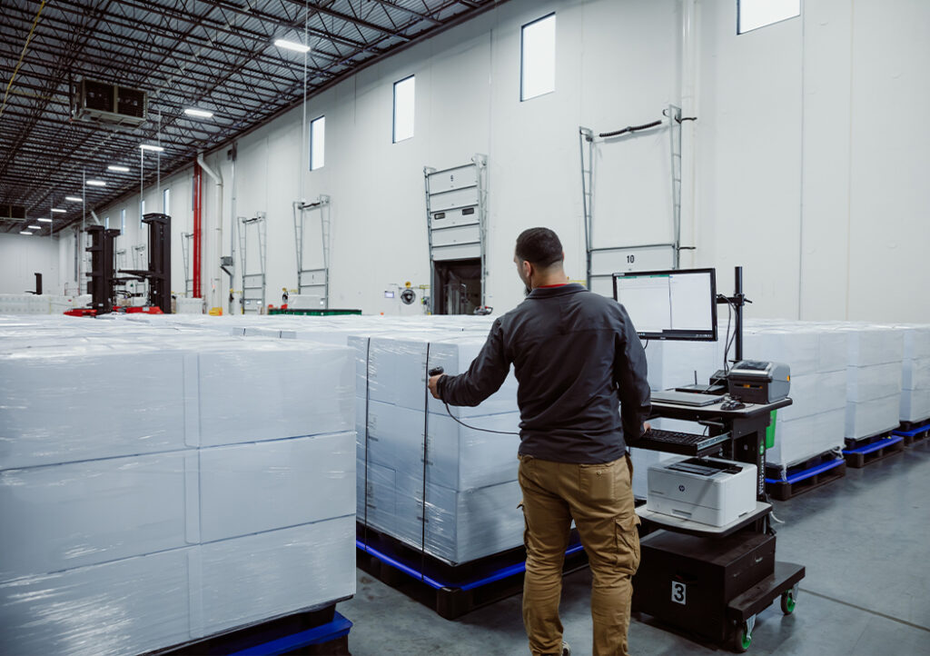 Worker Inside Warehouse Performing Critical Inventory of Supplies For Clients