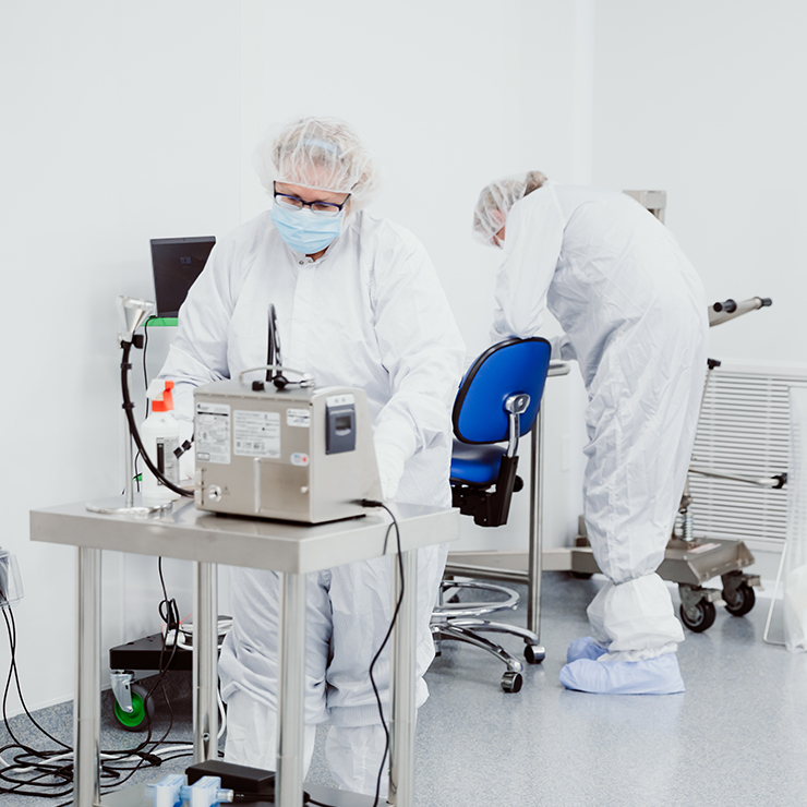 Two Certified Personnel Performing Pharmaceutical Sampling of Products in Full Sterile Gowns