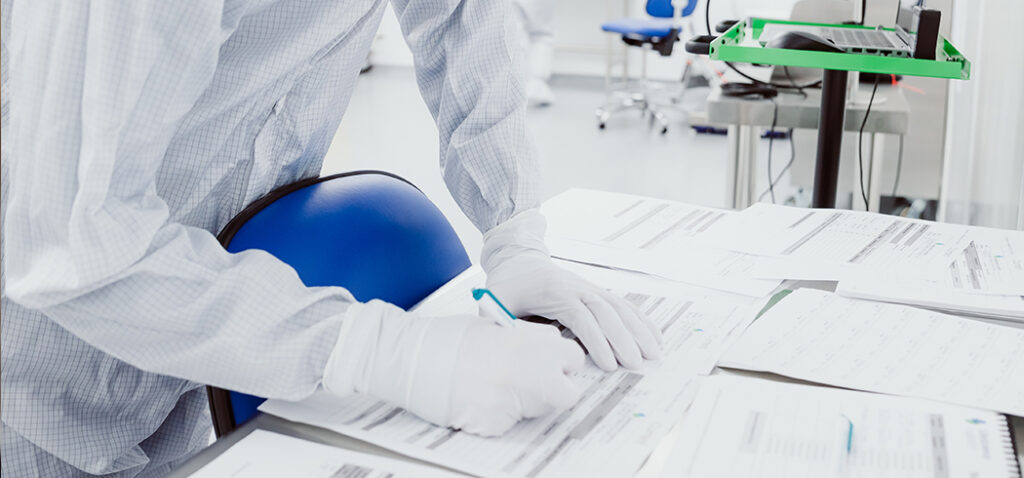 Staff in Protective PPE Gear Inside the Lab Signing Documents for State Mandate and Compliance 