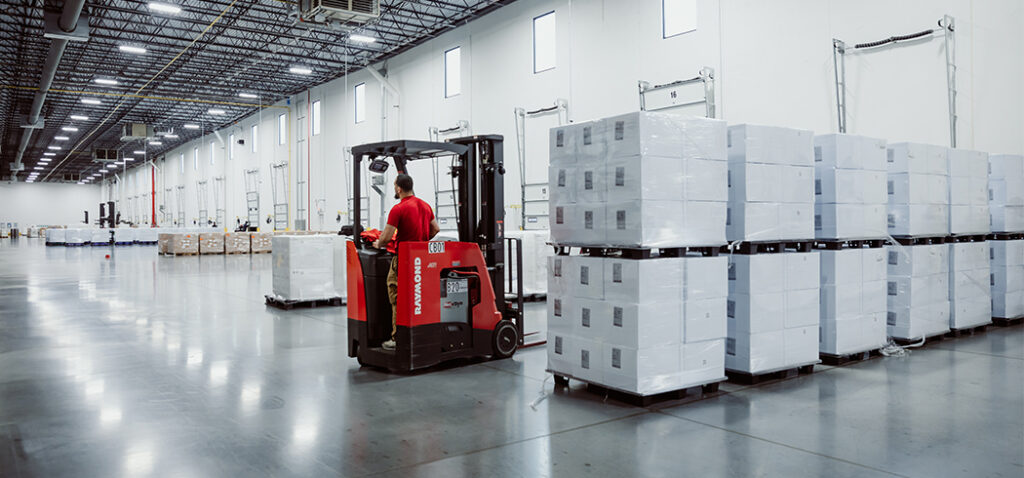 Worker Handling Boxes in Warehouse Ensuring Constant Supply Stockpile for Healthcare Clients