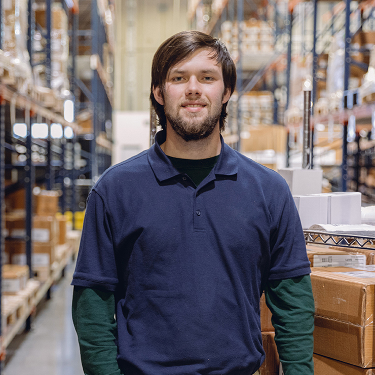 Male LSL Employee in the Warehouse Surrounded by Supply Boxes